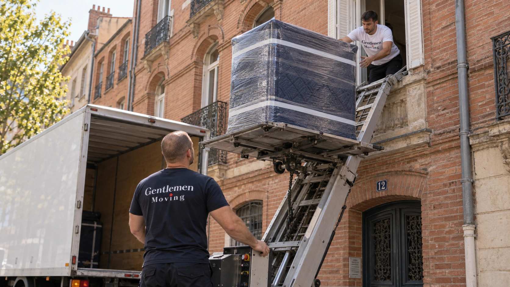 Monte-meubles dressé sur une façade en brique, une commode entièrement filmée monte vers la fenêtre