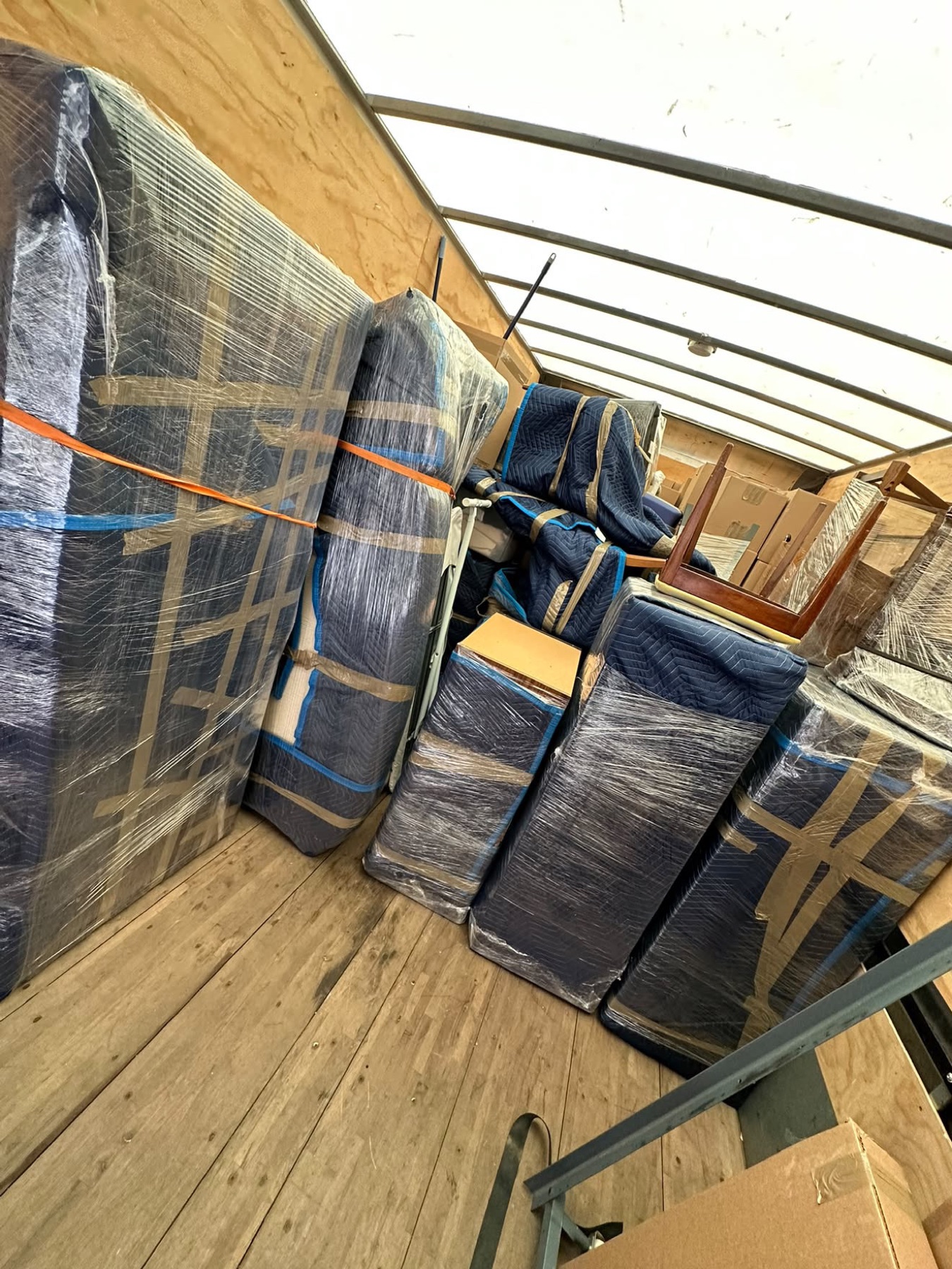 Meubles sous couvertures de déménagement et sanglés dans un camion