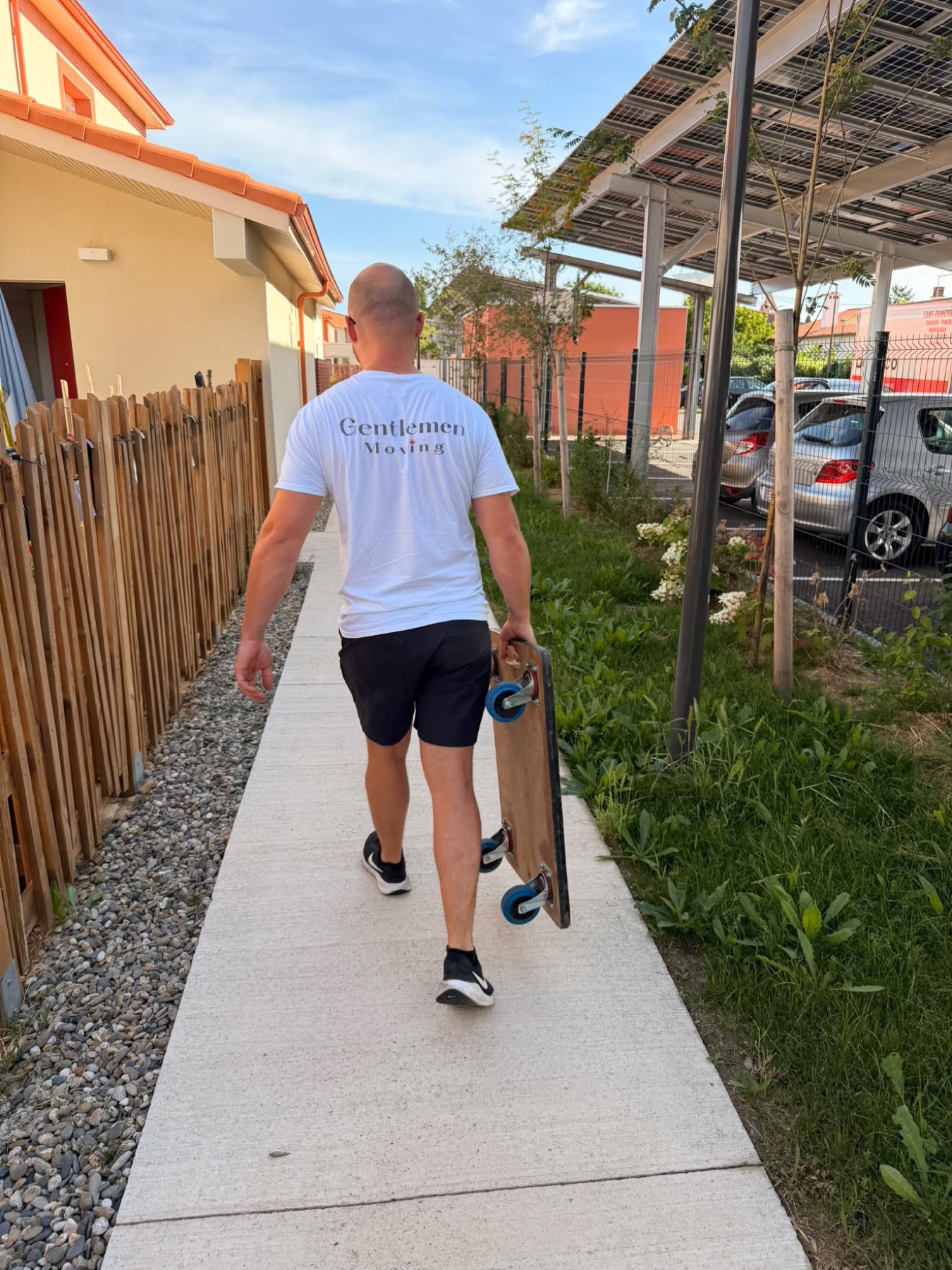 Déménageur en t-shirt floqué arrivant chez un client avec un plateau roulant