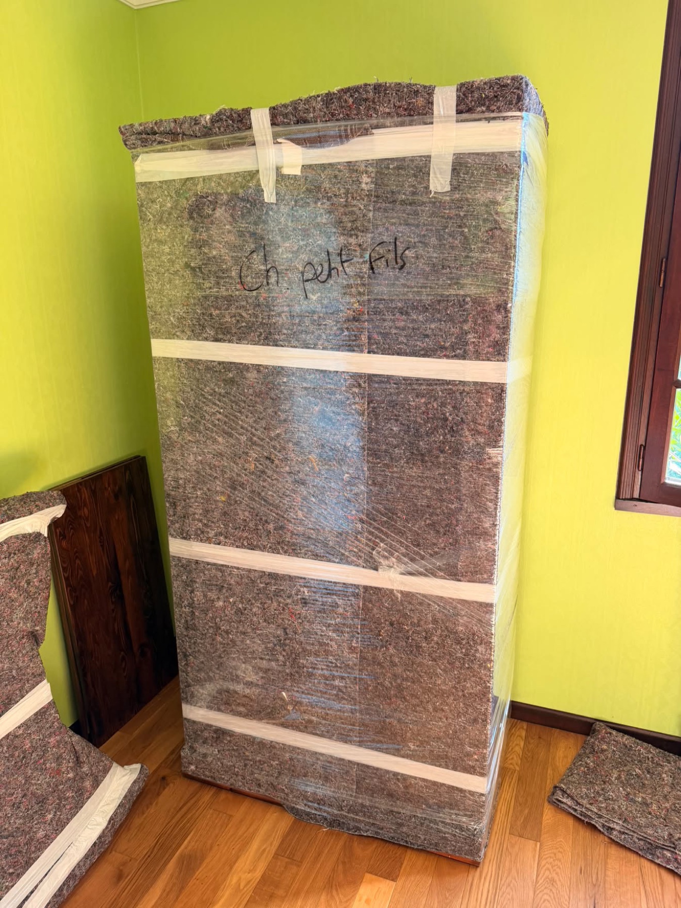 Armoire protégée par une couverture en feutre brun et annotée au marqueur