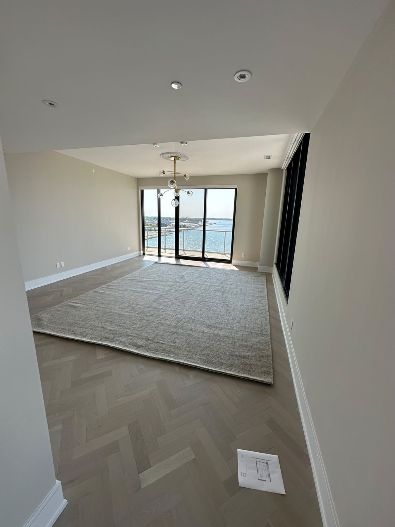 Logement vidé et rendu propre, parquet à chevrons et baie vitrée